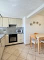 wooden cabinets, granite countertops, built-in microwave, electric oven, dishwasher, dining table, chairs, sink, faucet