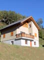 2 story house, beige and wooden exterior, balcony, chimney, raised ground floor