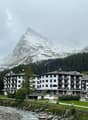 An apartment complex with 3 stories and a mountain in the background