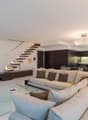 white walls, white floor, large sofa, dining table, television, cabinet with television