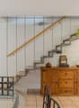 open space living area, stairs, wooden floor, dining table, chairs, kitchen cabinets, chandeliers
