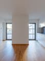modern kitchen, wood floors, white walls, two large windows, central pillar, countertops, modern sink, faucet, built-in appliances