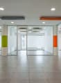 Wide hallway, tiled flooring, glass walls, no furniture visible