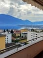 Balcony, tiled floor, railing, surrounding buildings, city view, lake view, mountain view