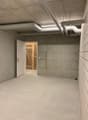 concrete walls, white floor, open door to wooden gate, large room