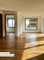 Open room, hardwood floors, two doors, double windows, sliding doors, balconies, view of trees