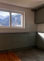 modern kitchen, gray cabinets, black countertops, window with mountain view, sink with faucet