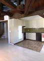 kitchen with wooden beams, white cabinets, tiled floor, dishwasher, sink, stove