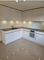 modern kitchen with white cabinets, granite countertop, stainless steel sink, built-in oven and stove, under-cabinet lighting