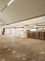 Large warehouse space, high ceilings, pallet racking, stackable boxes, white walls, white lighting, white floor
