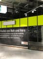 Yellow and green panels with a glass entrance and an advertising banner for 'coop'