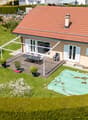 single story house, terracotta roof, outdoor table, covered patio, grassy backyard, swimming pool