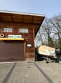 Wooden building with 2 garages, sign reading Nicolet Marine, boat with an outboard motor