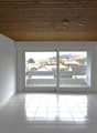 white tile floor, large windows with balcony, wooden ceiling, view of the town