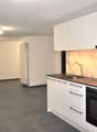 empty kitchen with white cabinets, tiled floor, sink, oven, large fridge