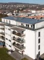 multi-story building with balconies on each floor, located in a suburban area