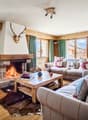 wooden interior, fireplace, carpet, lamp, two couches, center table