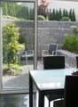 glass doors, large windows, outdoor chairs, dining table, view of the garden