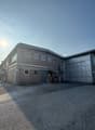 two story brick building, large garage, wide asphalt parking area