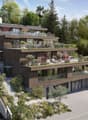 multi-story house, brown exterior, solar panels, multiple balconies, green terraces, parking area