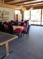 spacious dining area, wooden walls, glass windows, wooden tables and chairs, tiled floor, large windows offering outdoor views