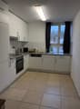 modern kitchen with tiled floor, integrated oven, dishwasher, window with curtain