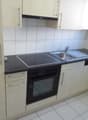 modern kitchen with white cabinets, black countertops, electric stove, oven, sink, dishwasher, and a window