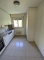 modern kitchen with white cabinets, tiled floor, sink, dishwasher, oven, window, radiator
