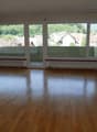 empty room, wooden floor, large windows, balcony, view of the mountains