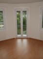 empty room, wooden floor, white walls, three windows, two radiators, balcony