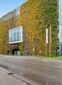 Modern glass and steel structure with a vertical garden covering a large section of the building.