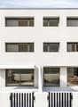 white modern house, large windows, multiple balconies, outdoor seating