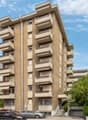 7-story building, multiple balconies, multiple cars parked in front
