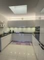 modern kitchen, white cabinets, white tiled floor, black countertops, stainless steel appliances, skylight