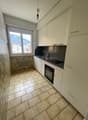 modern kitchen, tiled floor, white cabinets, black countertops, window with mountain view