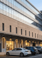 modern building, glass windows, brick wall, multiple cars parked in front