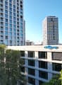 Tall modern high-rise buildings with glass facades, surrounded by trees. The building in the foreground has the 'Citypop' logo on it.
