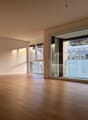 wooden floor, empty room, large sliding glass doors with balcony, tall white shelves