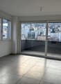 empty room, sliding glass door to balcony, tile flooring, windows, balcony with view