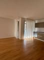 Open kitchen, hardwood floors, white walls, large windows, sliding doors, kitchen island, stainless steel appliances