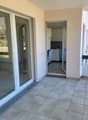 empty balcony with large glass sliding doors, tile flooring, leading to kitchen