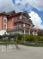 3 story house, pink and white exterior, balconies, garage, garden, street view