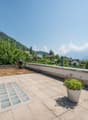 tiled floor, potted plant, wall, railing, mountain view