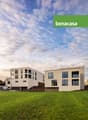 2 modern apartment buildings with balconies, multiple glass windows, elevated entrance