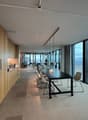 modern office space, with glass walls, white desks, beige carpet, wooden wall paneling, long conference table, office chairs, clear view