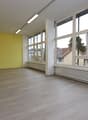 Yellow wall, white ceiling, hardwood floor, double height, multiple large windows, heater underneath the windows