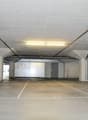 Underground parking lot with white concrete floor, white walls, concrete columns, bright lighting