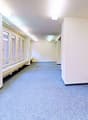 Empty room, white walls, blue carpet, windows, benches, lamps