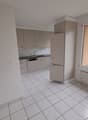 white tiles, kitchen area, cabinet with sink, refrigerator