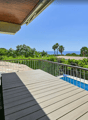 wooden terrace, metal railing, wooden table, swimming pool, sea view